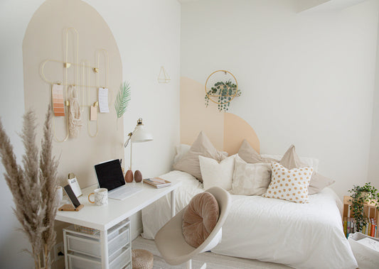 Man hanging a framed line-art print in a bright London flat